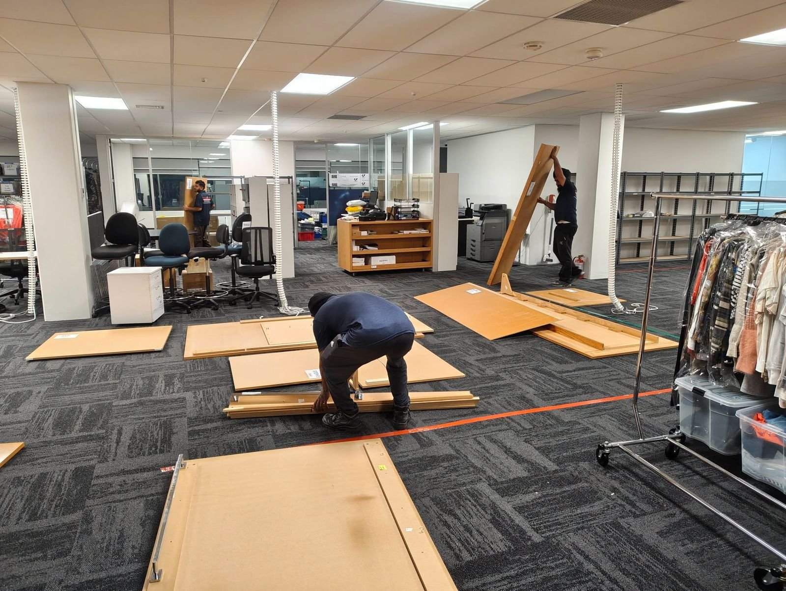 Hire professional movers Auckland – Big Bull Commercial crew disassembling office furniture and shelving during a commercial relocation