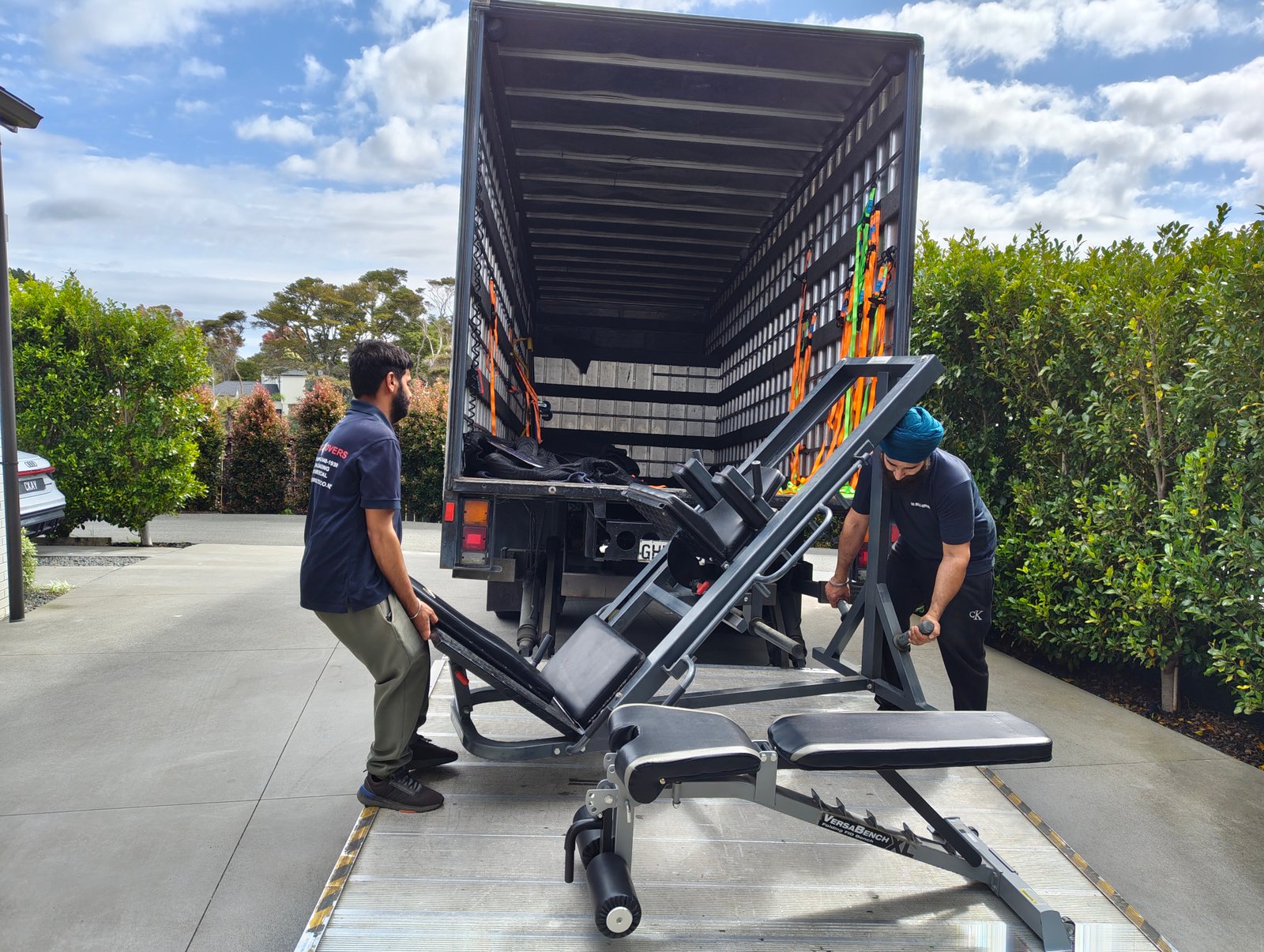 Professional movers transporting heavy gym equipment during a gym relocation in Auckland